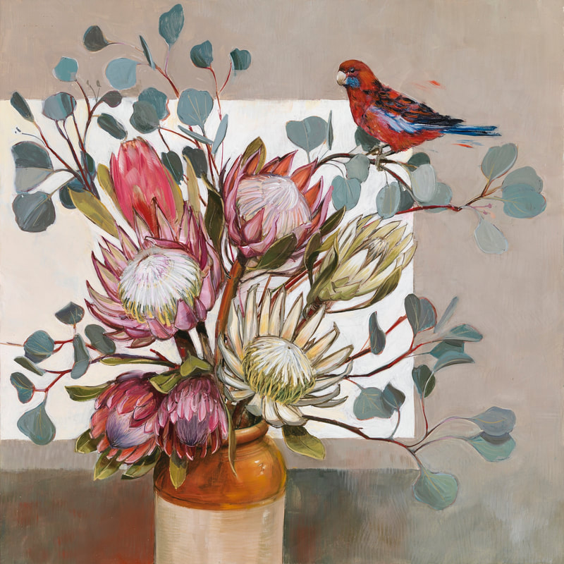 Pink & red protea flowers and grey gum leaves in stoneware vase against white background Australian Crimson Rosella bird is perched on a branch on right